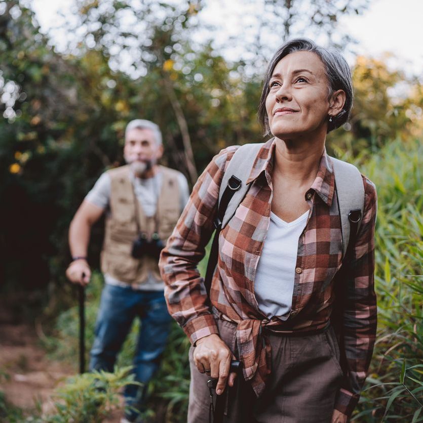 Senior couple walking on forest mountain trail
