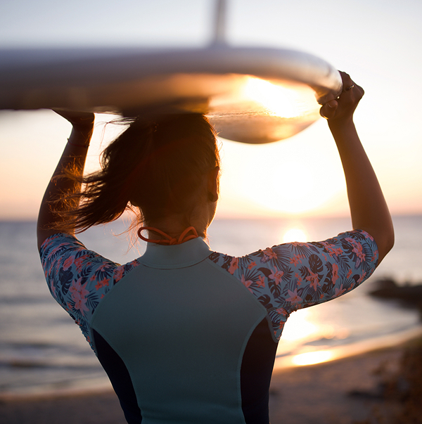 Surfer making her way to the water with her surfboard